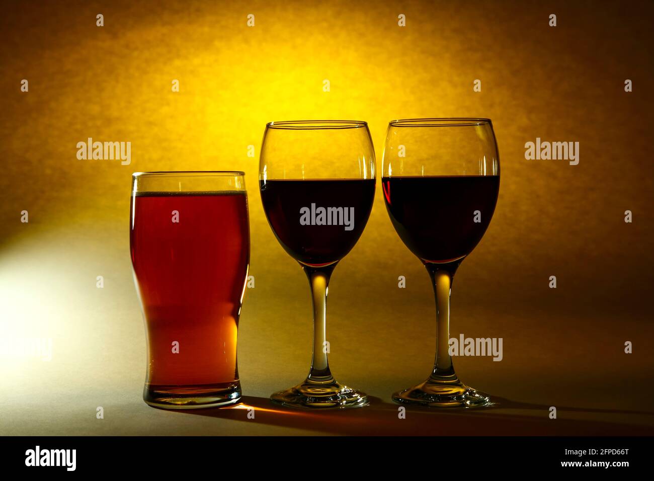 Due bicchieri di vino ripieni di vino rosso e una pinta bicchiere di birra Foto Stock