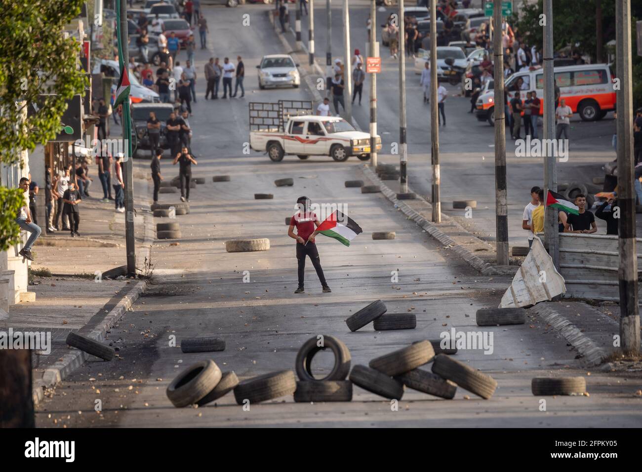 (210520) -- BETHLEHEM, 20 maggio 2021 (Xinhua) -- UN manifestante detiene una bandiera palestinese durante una protesta contro i continui attacchi aerei israeliani sulla striscia di Gaza, nella città di Bethlehem, in Cisgiordania, il 20 maggio 2021. Dall'inizio della campagna militare israeliana del 10 maggio, Israele ha colpito Gaza con attacchi aerei e artiglieria che hanno distrutto edifici residenziali, strade e altre infrastrutture. Secondo i funzionari sanitari palestinesi della striscia di Gaza, almeno 227 palestinesi sono stati uccisi, di cui 64 bambini e 38 donne. In Israele sono state uccise 12 persone, tra cui cinque anni Foto Stock