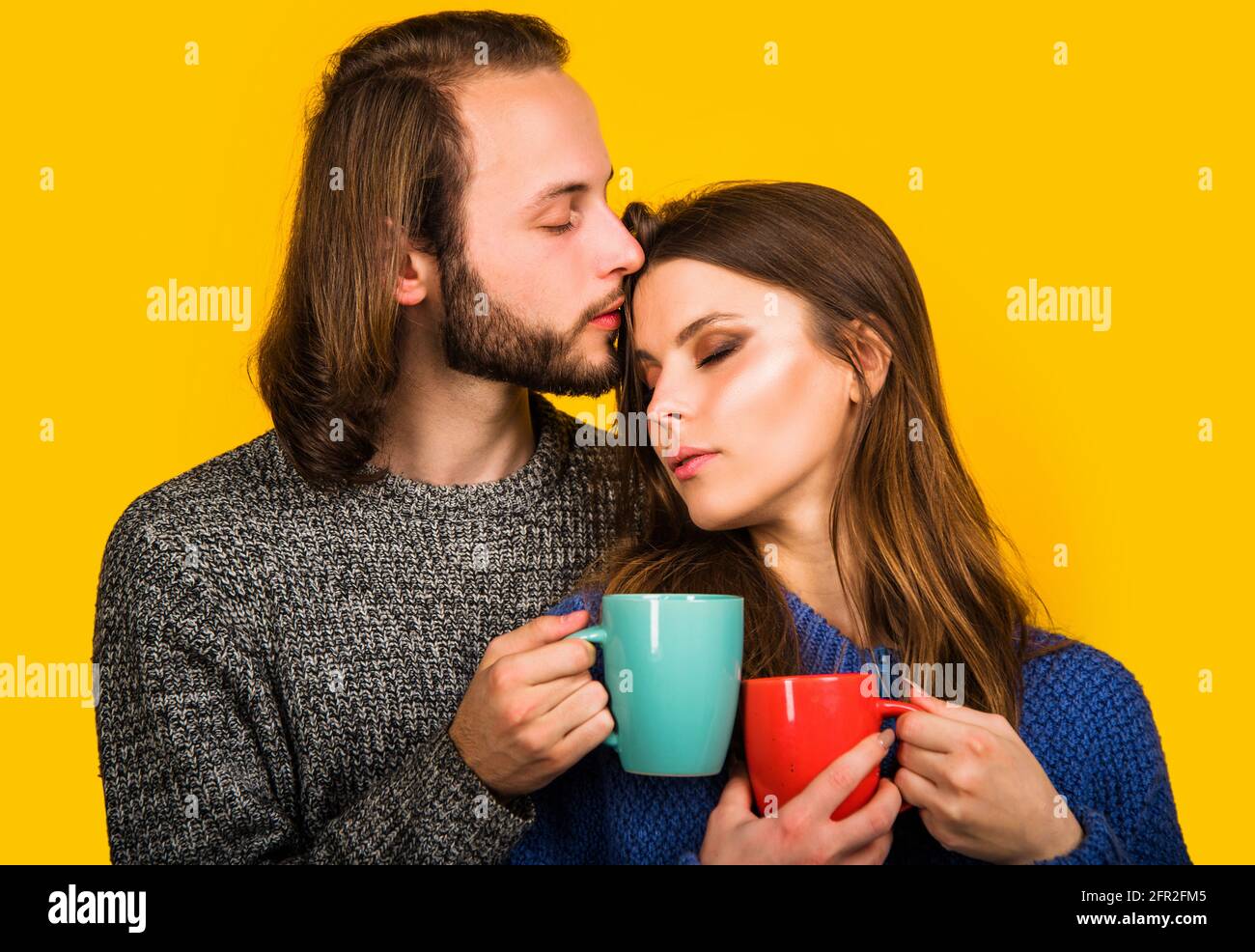 Concetto di intimità familiare. Accoppia in abiti caldi con una tazza di tè o caffè. Momenti romantici. Foto Stock