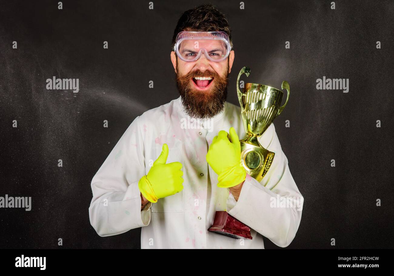 Servizio di pulizia professionale. Uomo con bearded in uniforme e guanti con coppa d'oro trofeo. Foto Stock