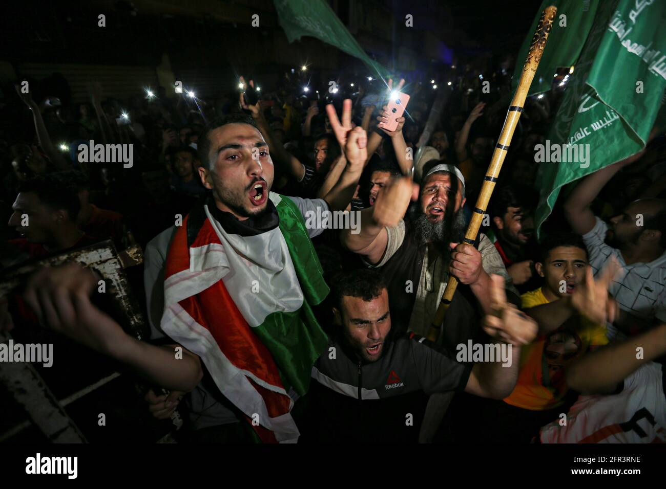 I palestinesi festeggiano per le strade dopo un cessate il fuoco, nella striscia di Gaza meridionale, il 21 maggio 2021. REUTERS/Ibraheem Abu Mustafa Foto Stock