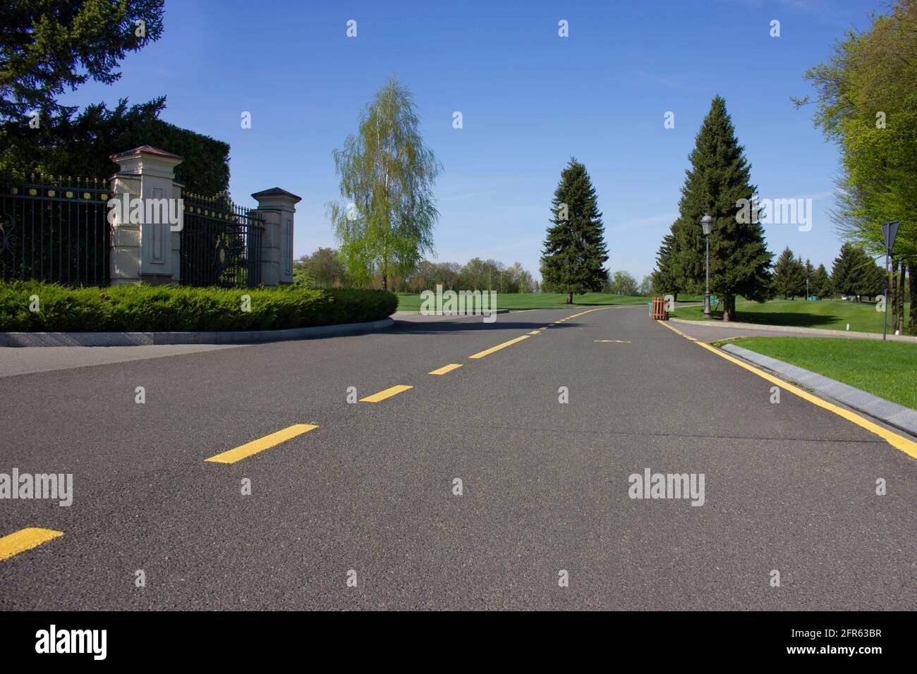 La strada che conduce al parco. Sentiero asfaltato per ciclisti e pedoni. Splendido paesaggio del parco primaverile Foto Stock