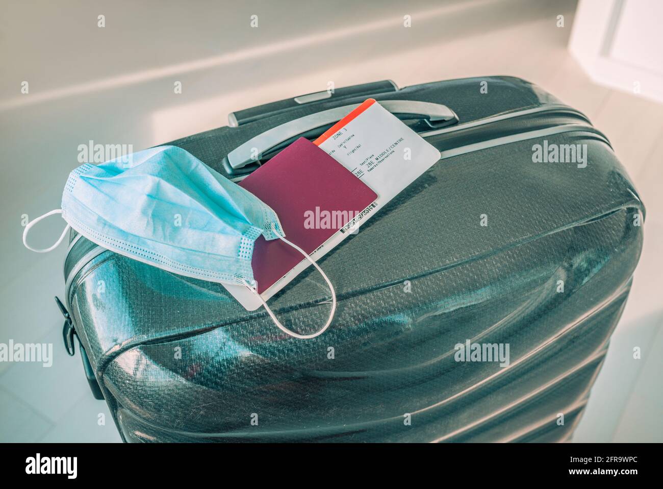 Restrizioni di viaggio durante la pandemia del coronavirus a seconda dei paesi che impongono la quarantena o il test negativo del Covid-19 alla frontiera. Maschera facciale e passaporto Foto Stock