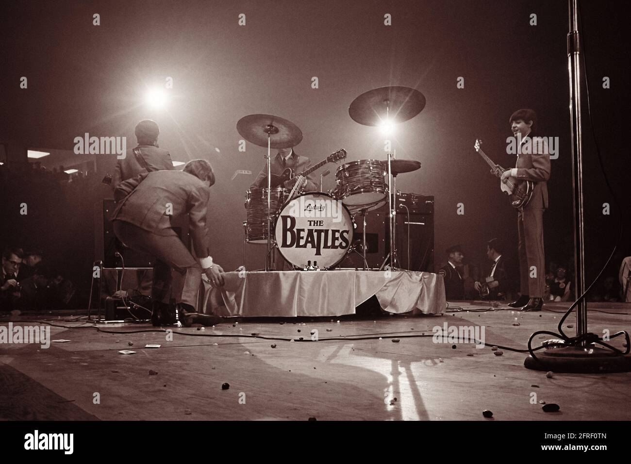 I Beatles si esibiscono al Washington Coliseum nel loro primo concerto americano il 11 febbraio 1964. Il palcoscenico è disseminato di fagioli di gelatina dai ventilatori che pelano la band con loro dopo che un giornale di New York ha riferito la band che discute un simile per loro. (STATI UNITI) Foto Stock