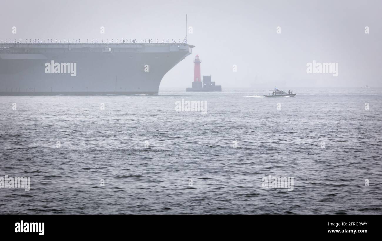 Una US Navy Aircraft Carrier viene scortata fuori dal porto di Yokosuka nella nebbia della Baia di Tokyo in Giappone. Foto Stock