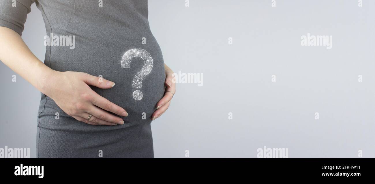 Donna incinta pancia con ologramma punto interrogativo. Concetto di gravidanza. Anticipazione della madre primo piano, spazio di copia. Foto Stock