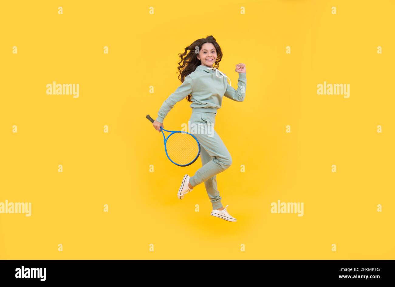 happy energico bambino salto in abbigliamento sportivo con racchetta squash running al successo, stamina. Foto Stock