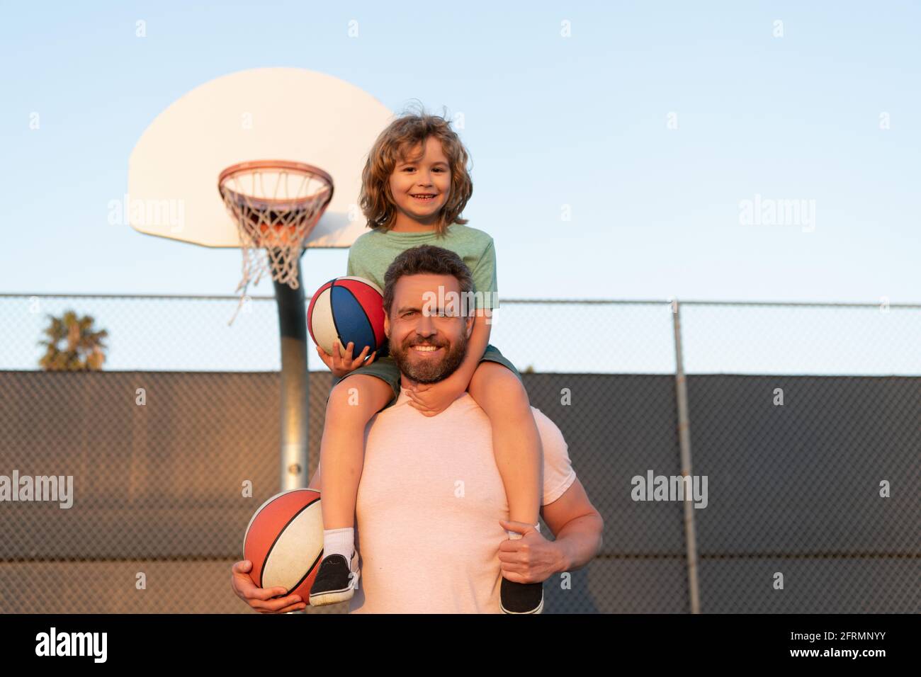 padre e figlio giocano a basket. buon giorno dei padri. famiglia felice. papà e ragazzo giocano a basket. Foto Stock
