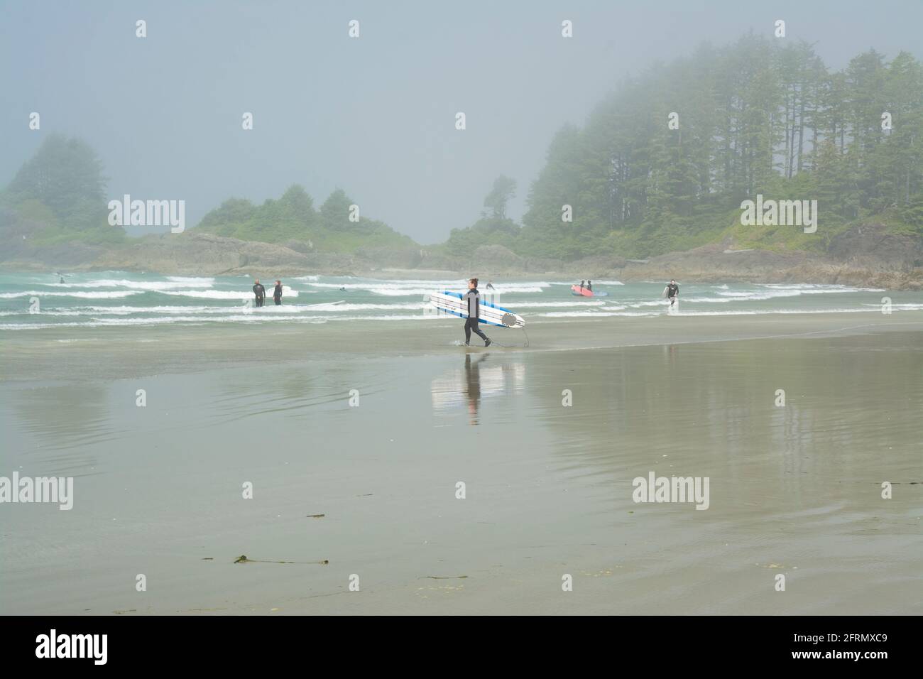 Surfers sulla spiaggia di Cox Bay a Tofino, British Columbia, Canada. Foto Stock