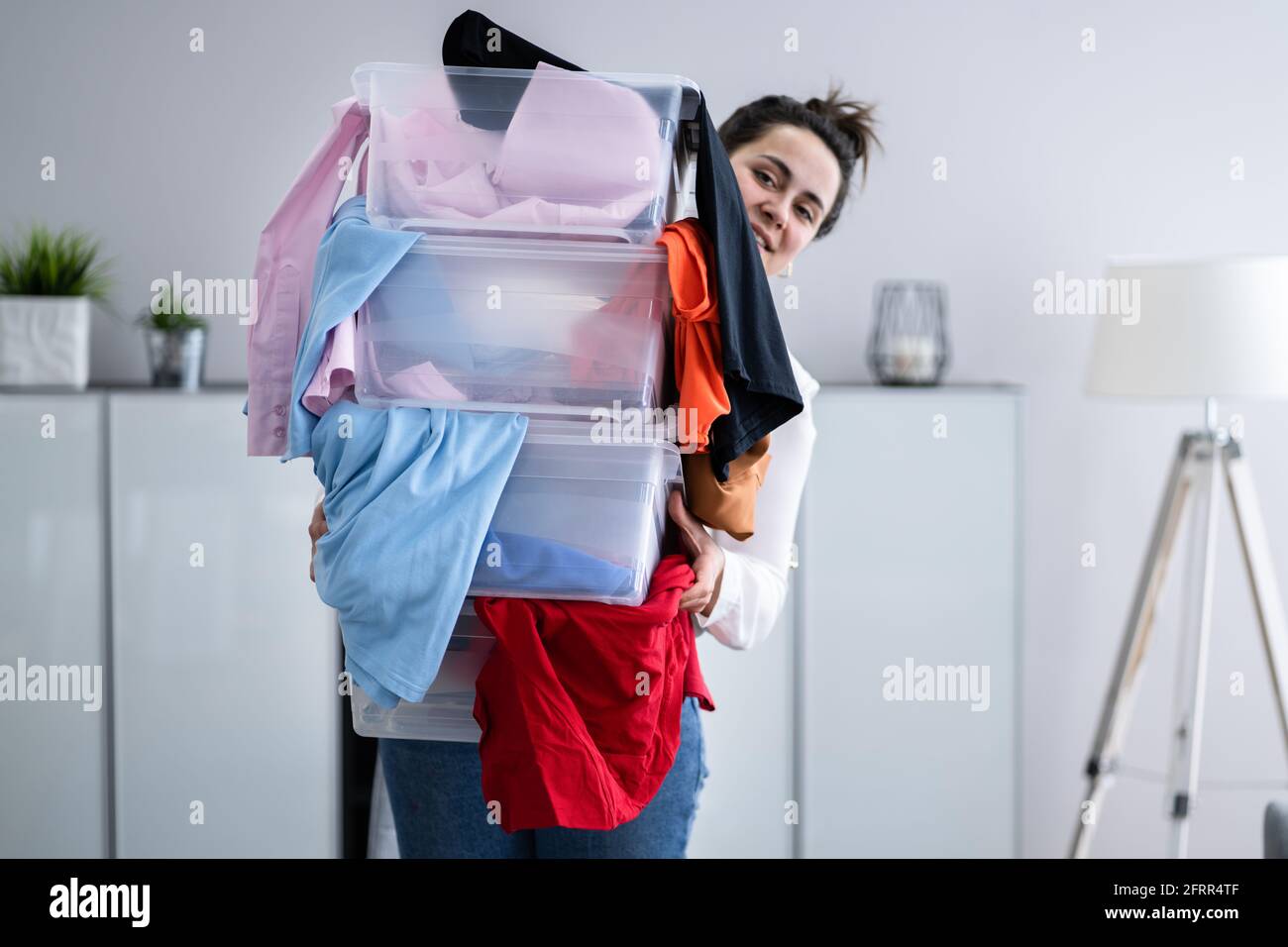 Donna decluttering e facendo lavanderia a casa Foto Stock