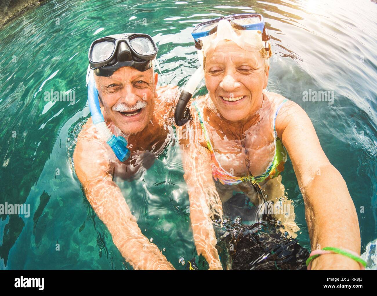 Felice coppia ritirata che prende selfie in escursione tropicale del mare con Macchina fotografica d'acqua e maschere da snorkeling - gita in barca snorkeling in scenari esotici Foto Stock