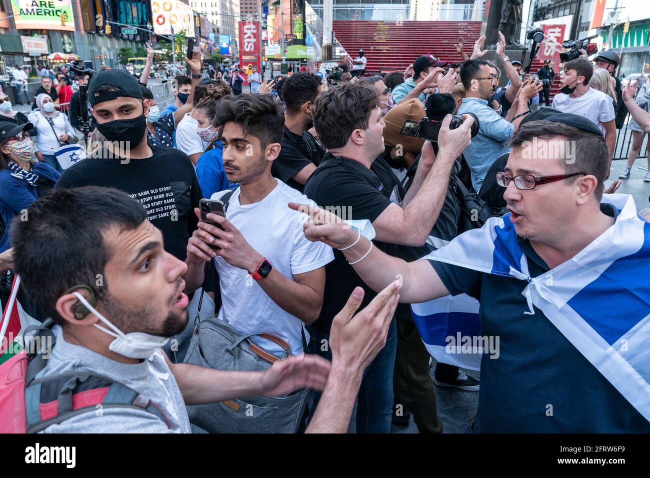 I manifestanti pro-Israele e pro-Palestinesi si scontrano tra loro su Times Square e le strade regolate. Mentre il rally ha iniziato pacificamente i manifestanti da entrambe le parti hanno cominciato rapidamente a intimidire e presto si sono scoppiati i combattimenti pugistici che hanno portato a molti arresti da parte della polizia. Alcune dozzine di manifestanti hanno partecipato da entrambe le parti. C'era bandiera israeliana che bruciava e i fuochi d'artificio sono stati lanciati da un'auto. Lo scontro tra i manifestanti si verifica quando Israele e Hamas hanno annunciato un cessate il fuoco per porre fine a una guerra di 11 giorni che ha causato una distruzione diffusa nella striscia di Gaza e la morte di molte persone su entrambi i lati della conca Foto Stock