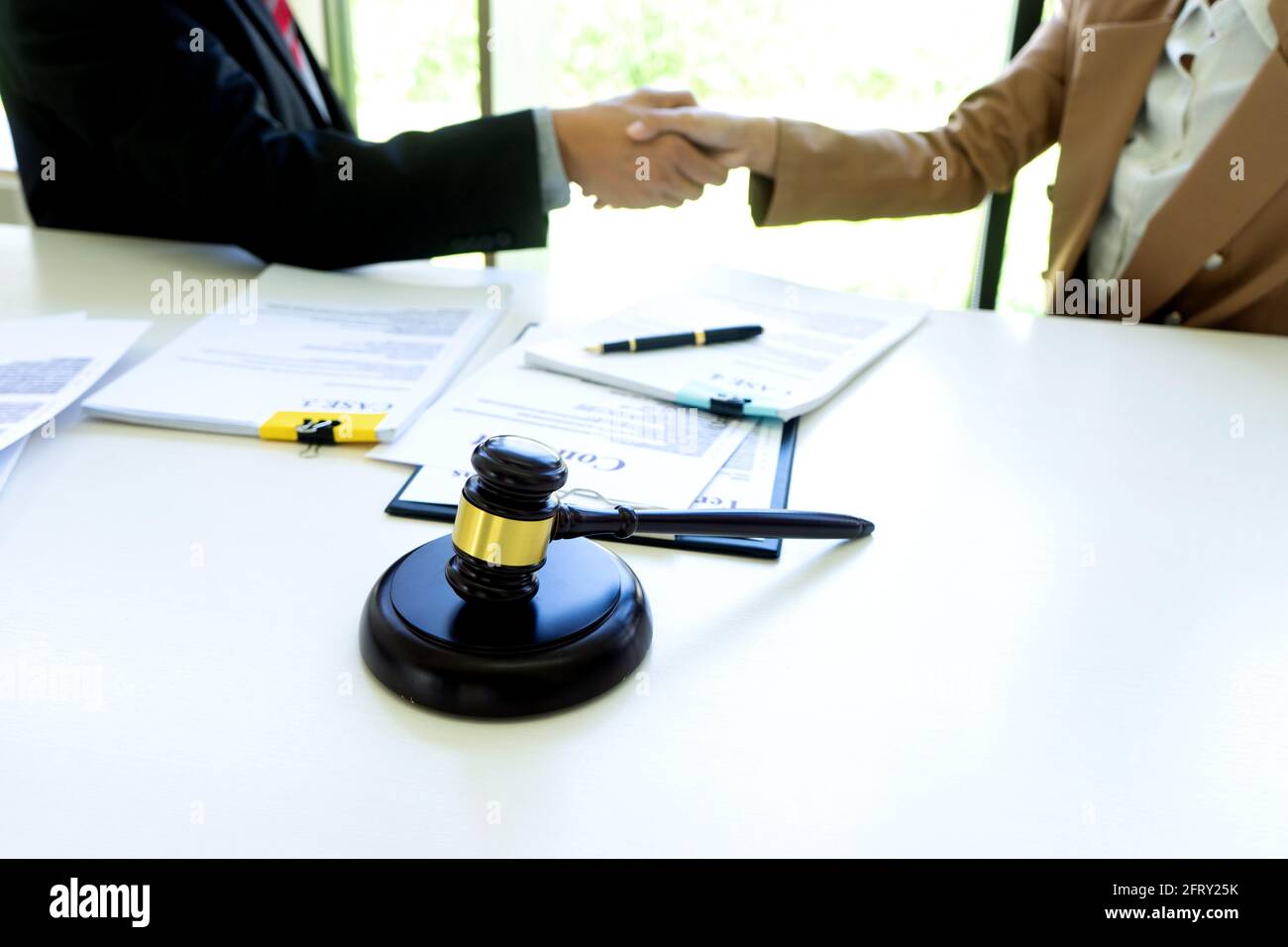 Avvocato o giudice con gavel e bilanciamento handshake con il cliente o il cliente su come utilizzare l'arbitrato Foto Stock