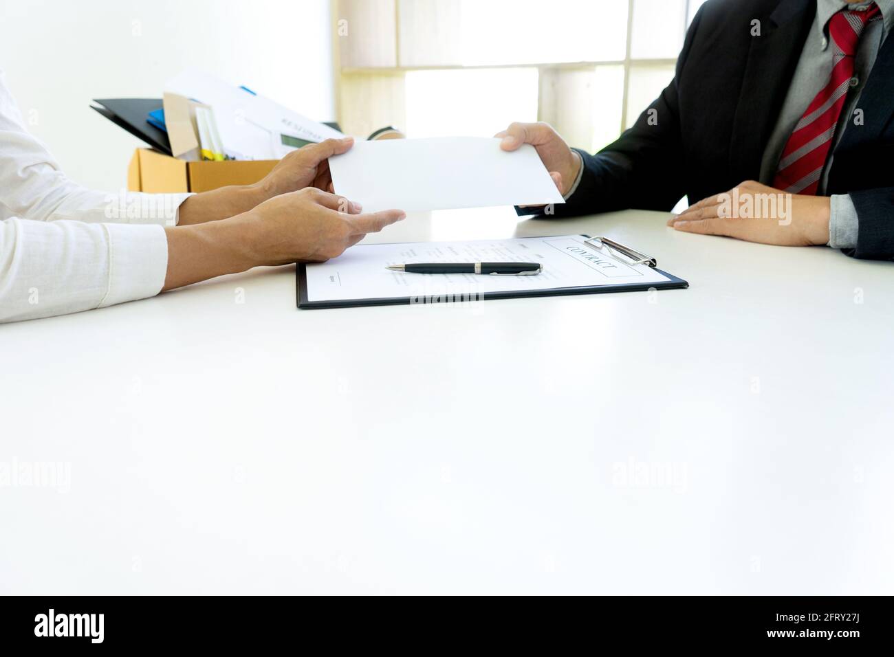 Il giovane lavoratore si sente male e triste, riceve la nota di dimettersi dal suo capo e la sua compagnia. Uomo d'affari triste imballare la sua appartenenza nella scatola e tornare a casa. Foto Stock