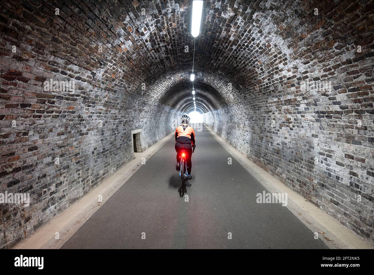 Ciclista femminile che cavalcano il Keswick a Threlkeld pista ciclabile, Lake District, Cumbria, UK. Foto Stock