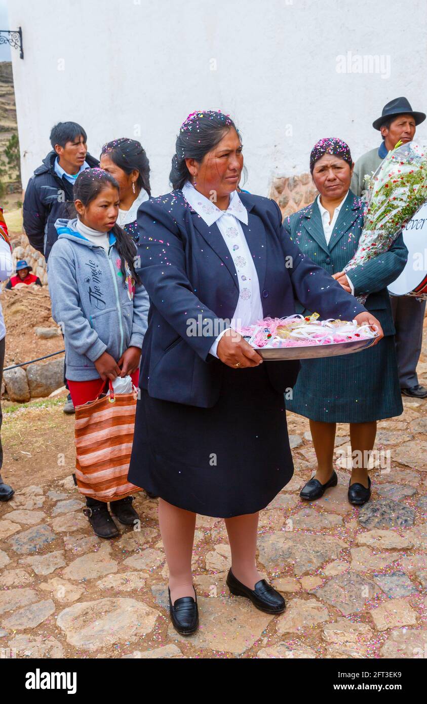 Donna locale Quechua che consegna regali di nozze in un matrimonio a Chinchero, un villaggio andino rustico nella Valle Sacra, Urubamba, regione di Cusco, Perù Foto Stock