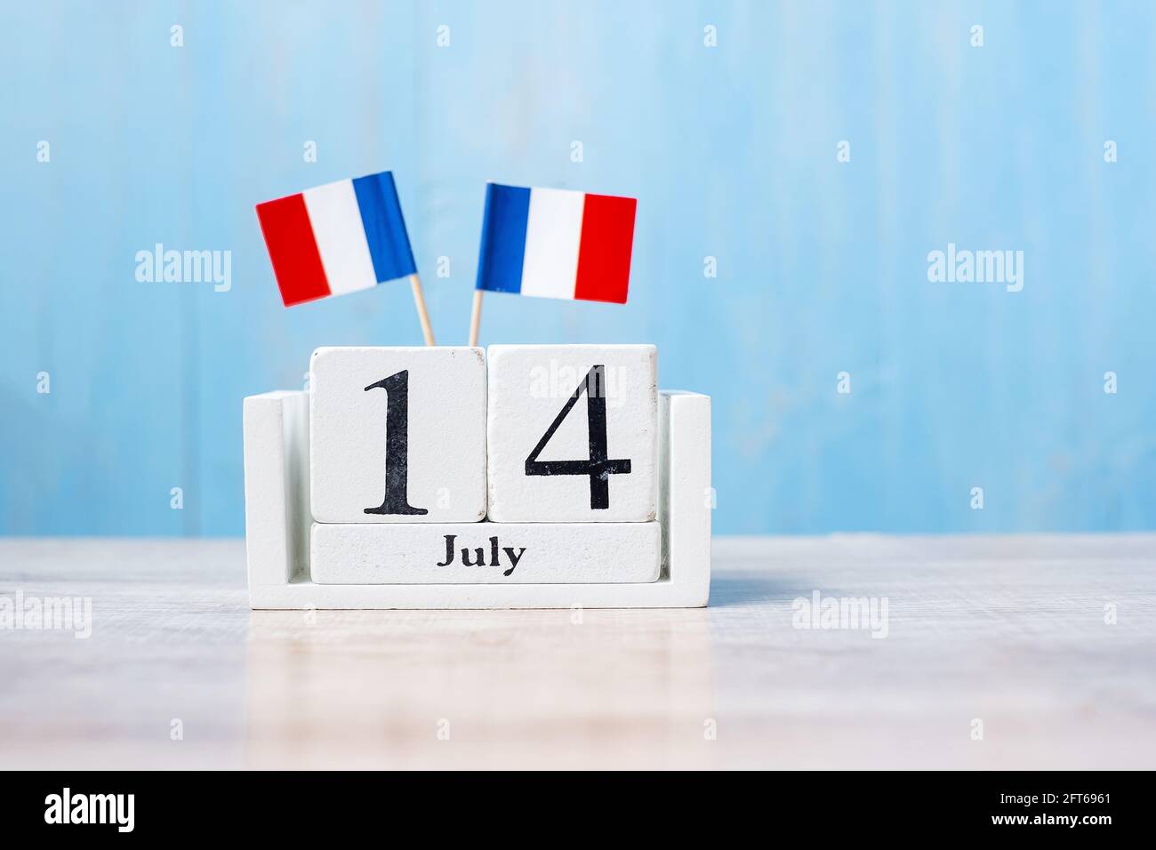 Calendario in legno del 14 luglio con bandiere Francia in miniatura. Festa nazionale francese, festa della Bastiglia e buone celebrazioni Foto Stock