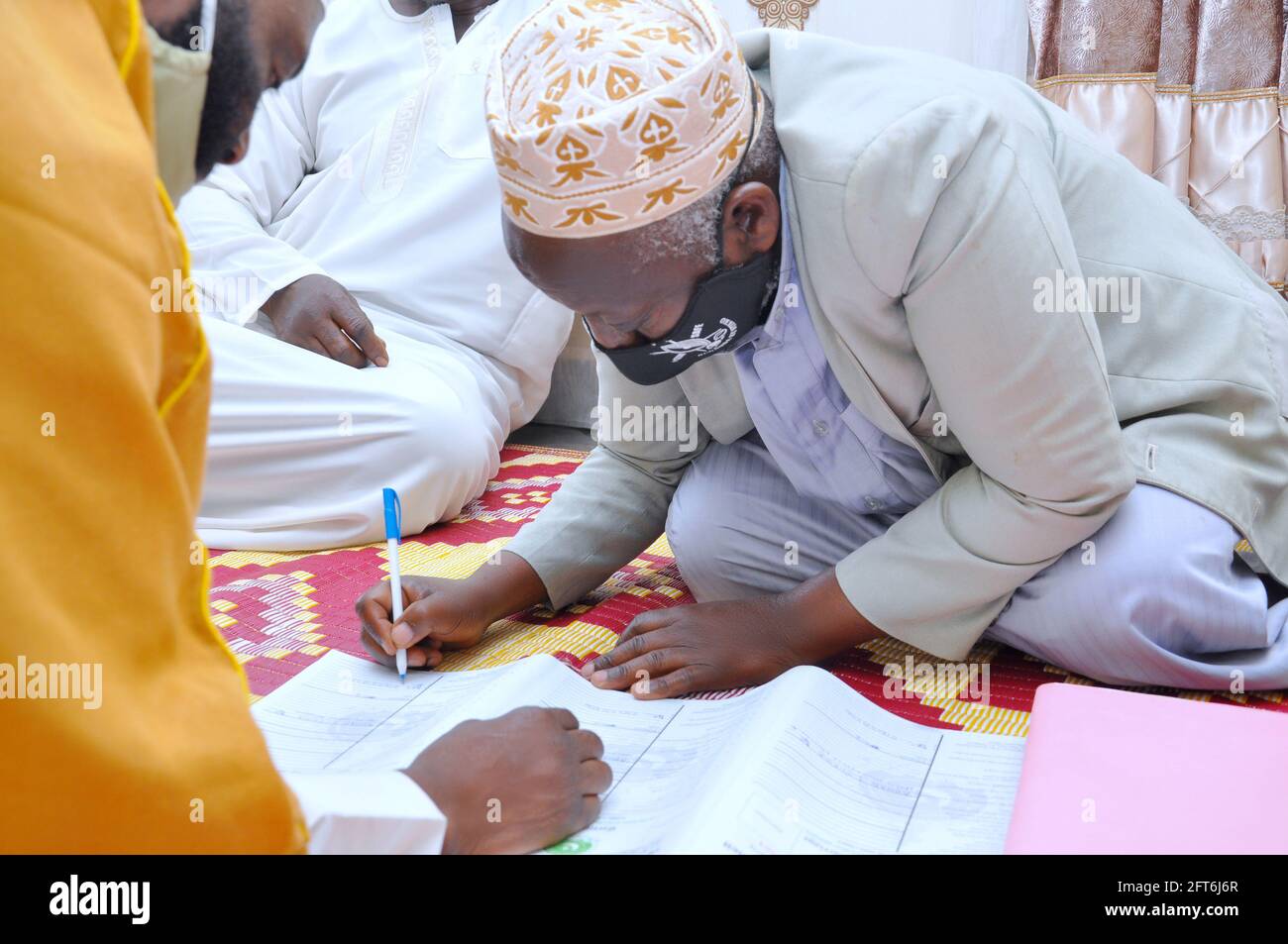 KAMPALA, UGANDA - 05 maggio 2021: I mariti musulmani firmano accordi di matrimonio per togliere le loro donne la via legale per i loro bei Foto Stock
