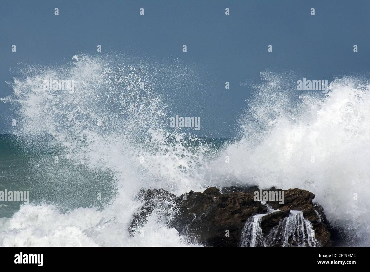Rottura dell'onda sulla roccia Foto Stock