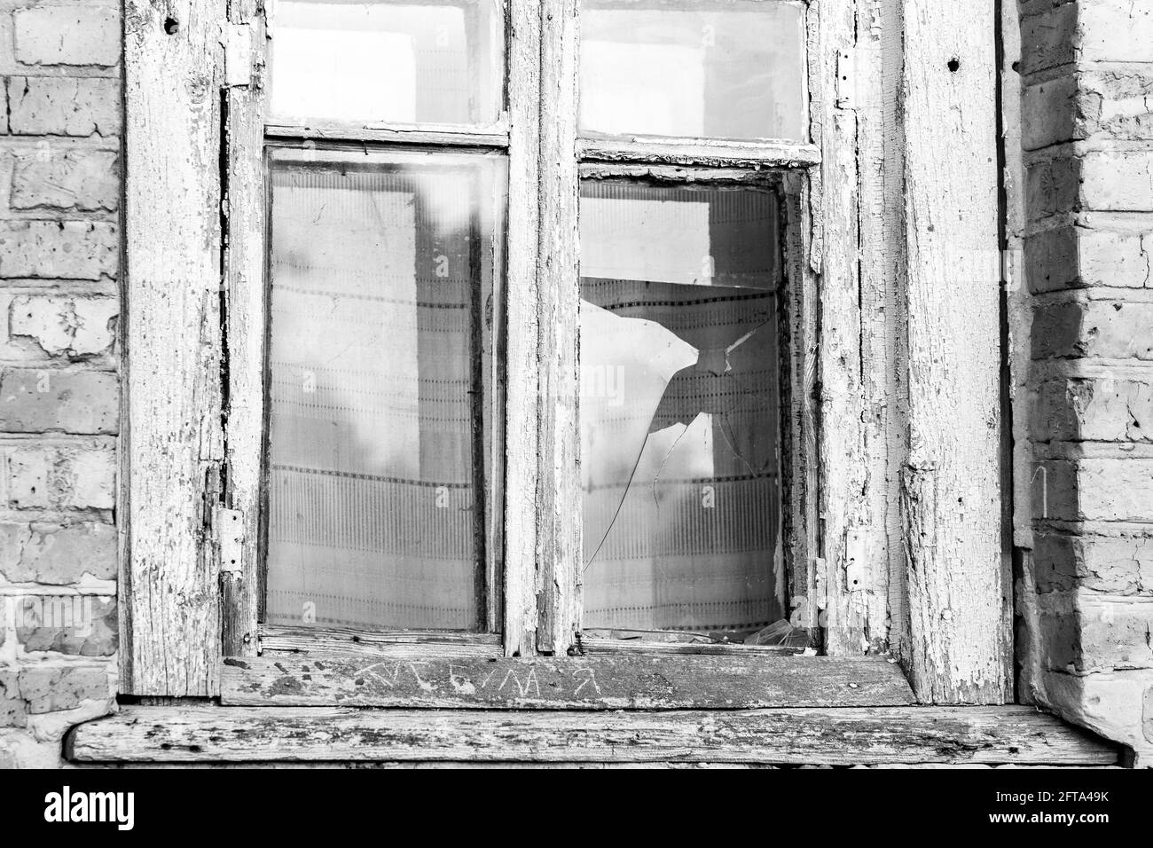 Finestra spezzata di una vecchia casa abbandonata. Immagine in bianco e nero. Foto Stock