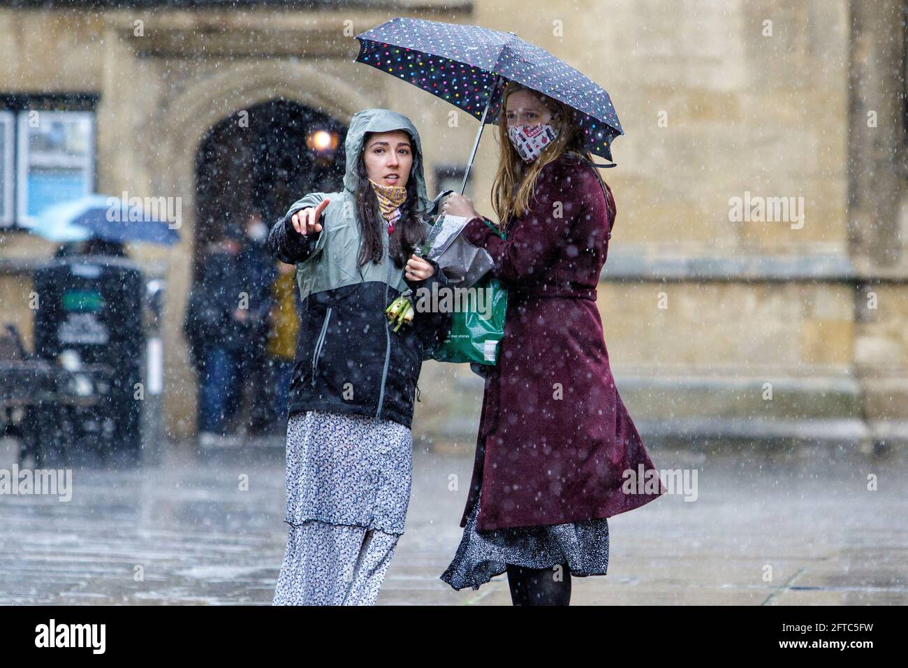 Bath, Somerset, Regno Unito. 21 Maggio 2021. Due donne che riparano sotto un ombrello sono raffigurate all'esterno dell'abbazia di Bath mentre le forti docce a pioggia fanno la loro strada attraverso il Regno Unito. Credit: Lynchpics/Alamy Live News Foto Stock