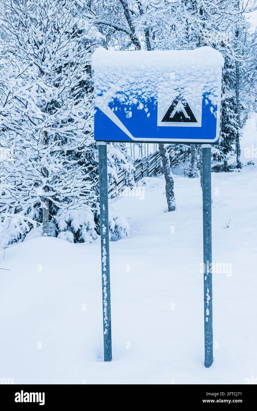 Cartello campeggio innevato su strada Foto Stock