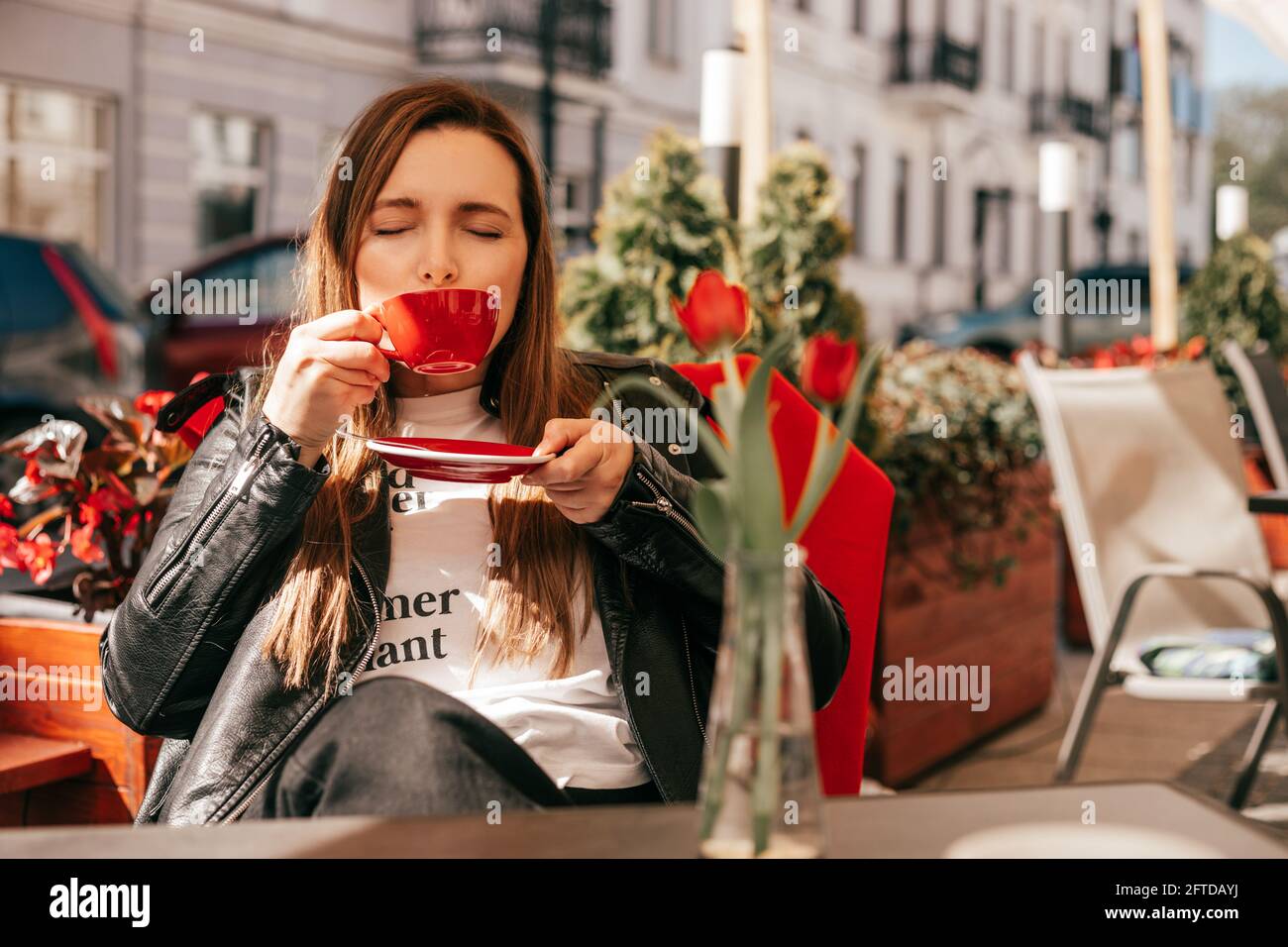 Donna che ama il caffè al tavolo del caffè di strada in rosso tazza Foto Stock