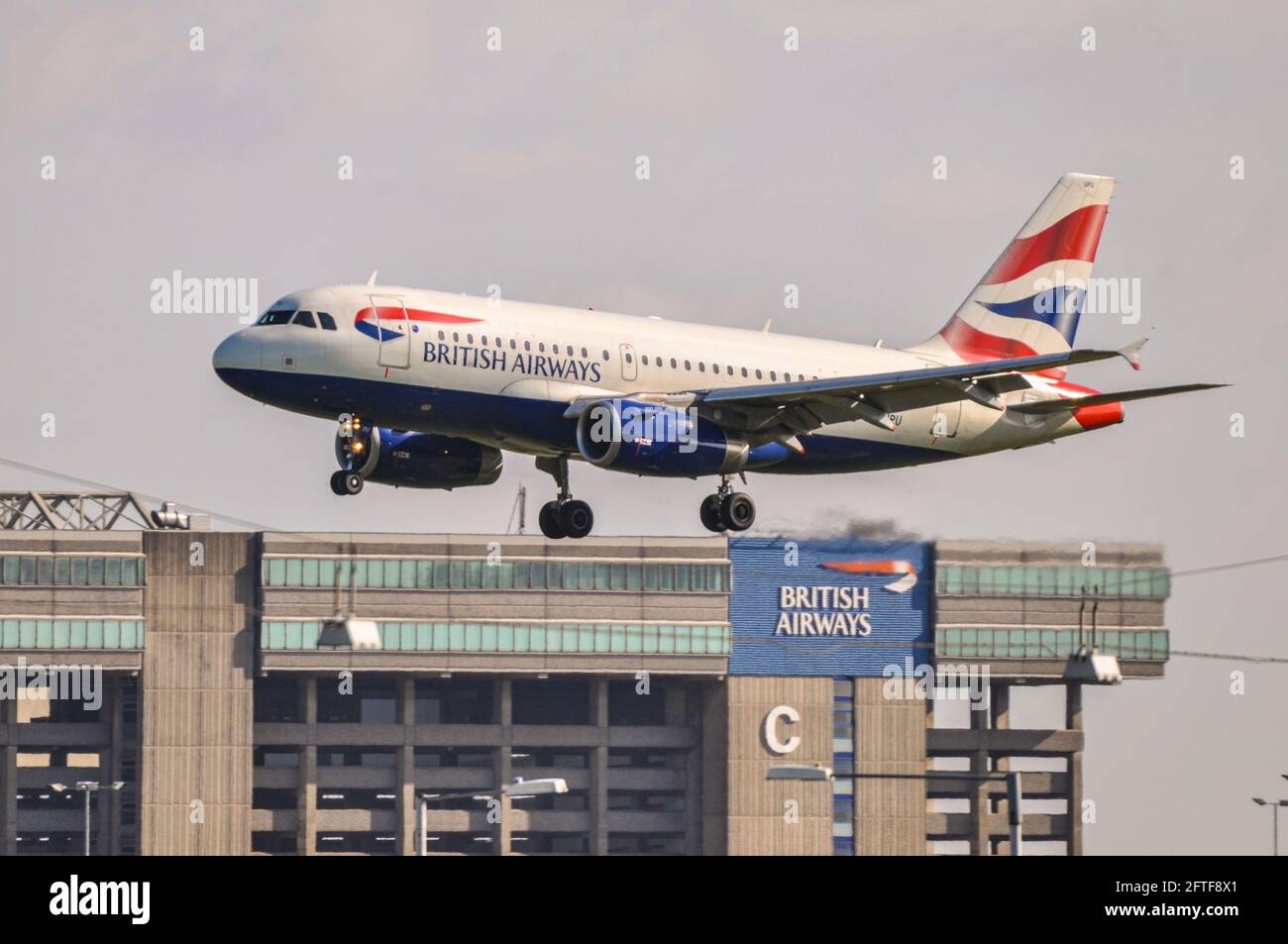British Airways Airbus A319 aereo jet G-EUPU atterrando all'aeroporto Heathrow di Londra, Regno Unito, sopra l'hangar della base di manutenzione della British Airways Foto Stock