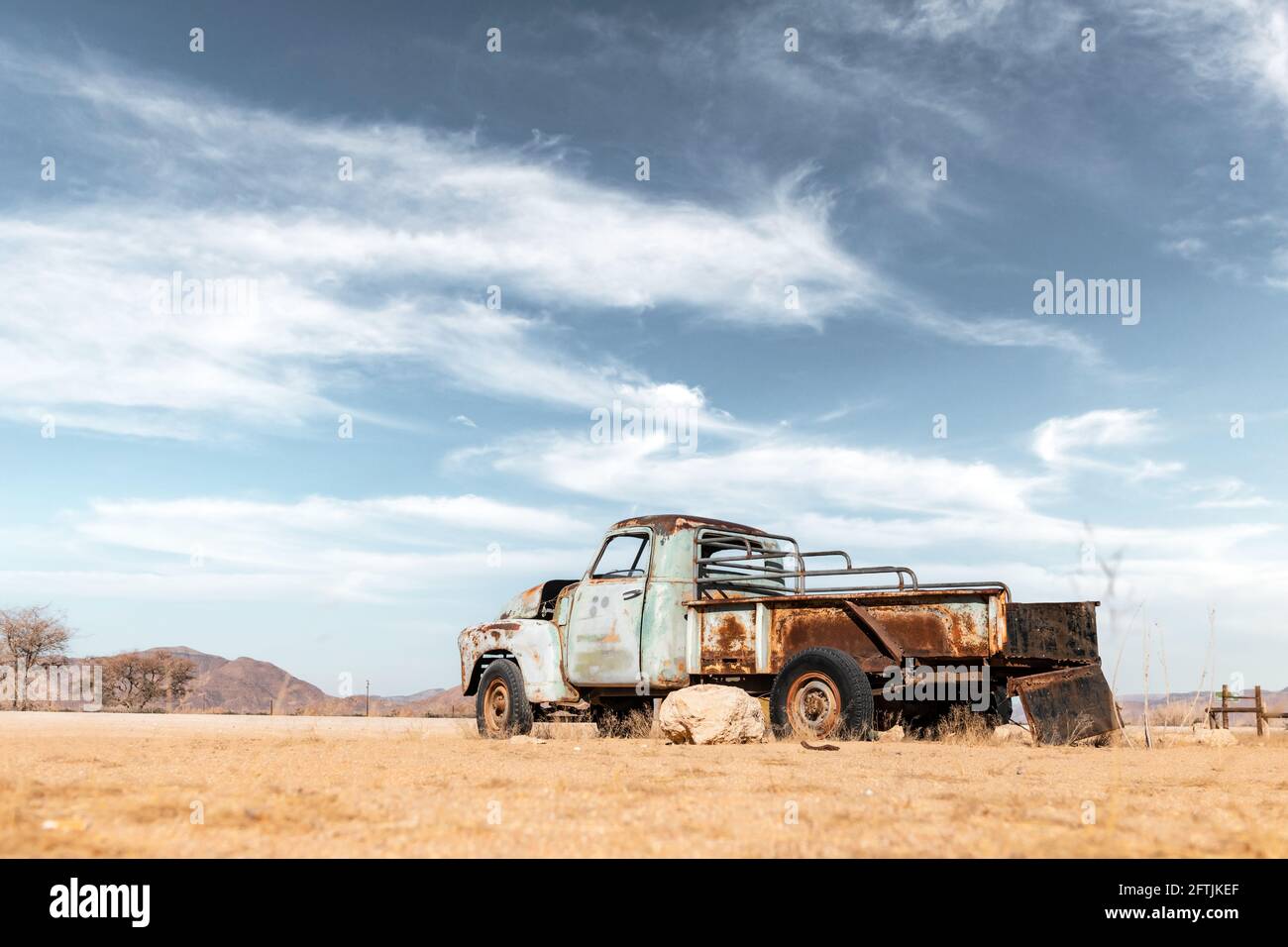 Abbandonata vecchia auto nel deserto sabbioso Foto Stock