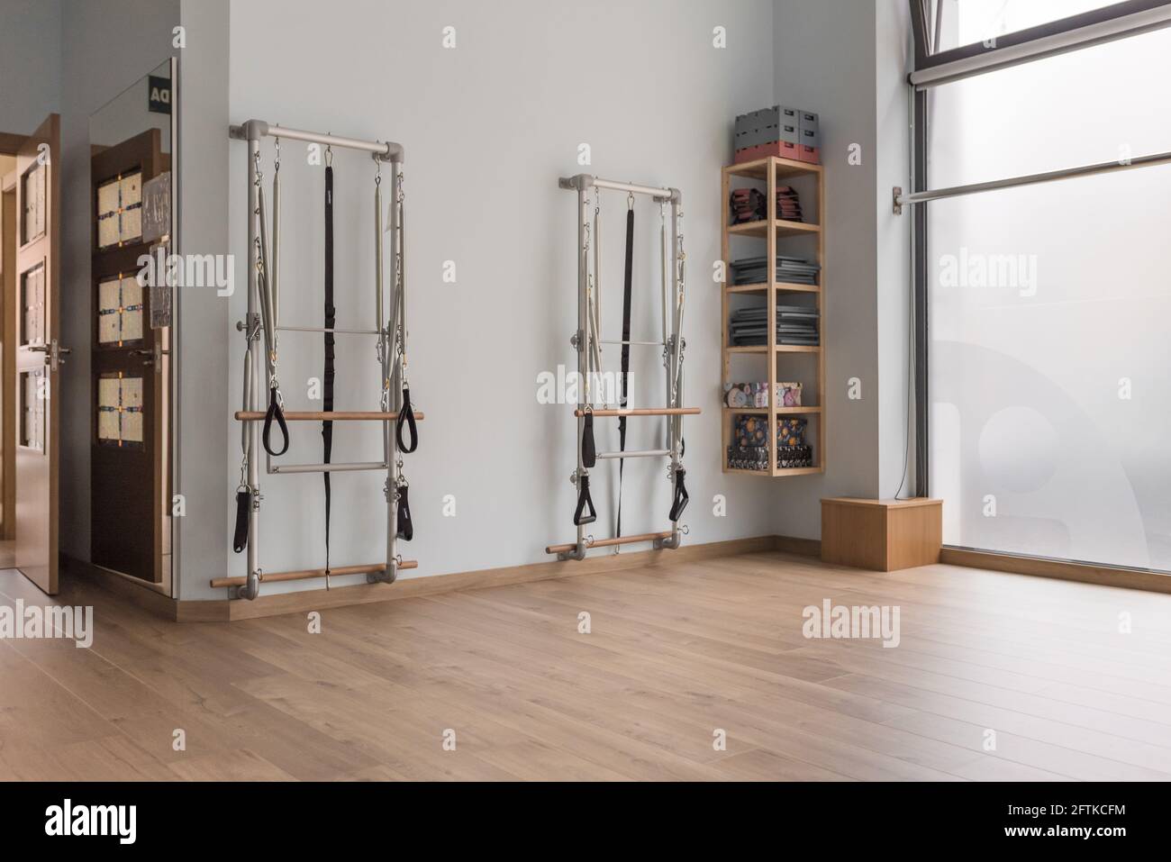 angolo di un pilates studio con due macchine e un ripiano. Pavimento e finestra in legno Foto Stock