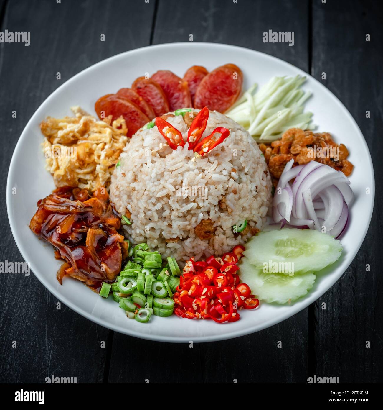 Un piatto di riso thai fritto con pasta di gamberi Sfondo di legno nero Foto Stock