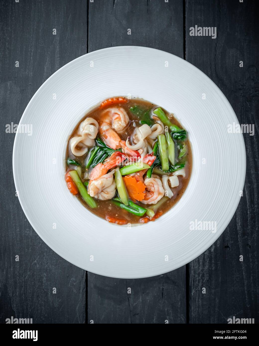 Un piatto di Thai Rat Na Noodle con frutti di mare, broccoli cinesi e salsa addensata Foto Stock