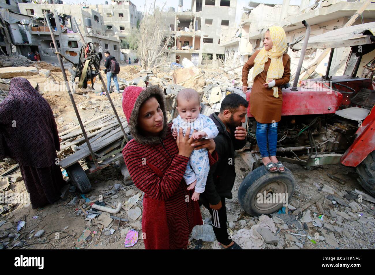 Gaza, Palestina. 21 Maggio 2021. La famiglia palestinese che è tornata nel loro quartiere, guarda ai danni della loro casa, colpiti dai bombardamenti israeliani nella città di Gaza. Un cessate il fuoco tra Israele e Hamas, il movimento islamista che controlla la striscia di Gaza, è sembrato detenere oggi dopo 11 giorni di combattimenti mortali che hanno fatto scoppiare l'enclave palestinese e hanno costretto innumerevoli israeliani a cercare rifugio dai razzi. (Foto di Ahmed Zakot/SOPA Images/Sipa USA) Credit: Sipa USA/Alamy Live News Foto Stock