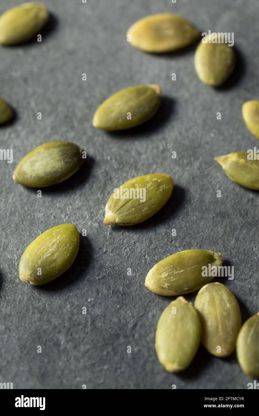 Semi di zucca organici verdi grezzi in una ciotola Foto Stock