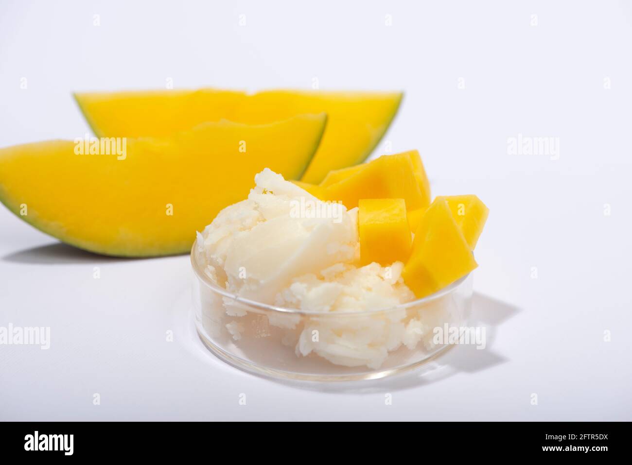 Burro di mango e frutta fresca di mango. Cosmetici biologici, cura della pelle, concetto spa. Ingridient per il cosmetic fatto in casa. Foto Stock