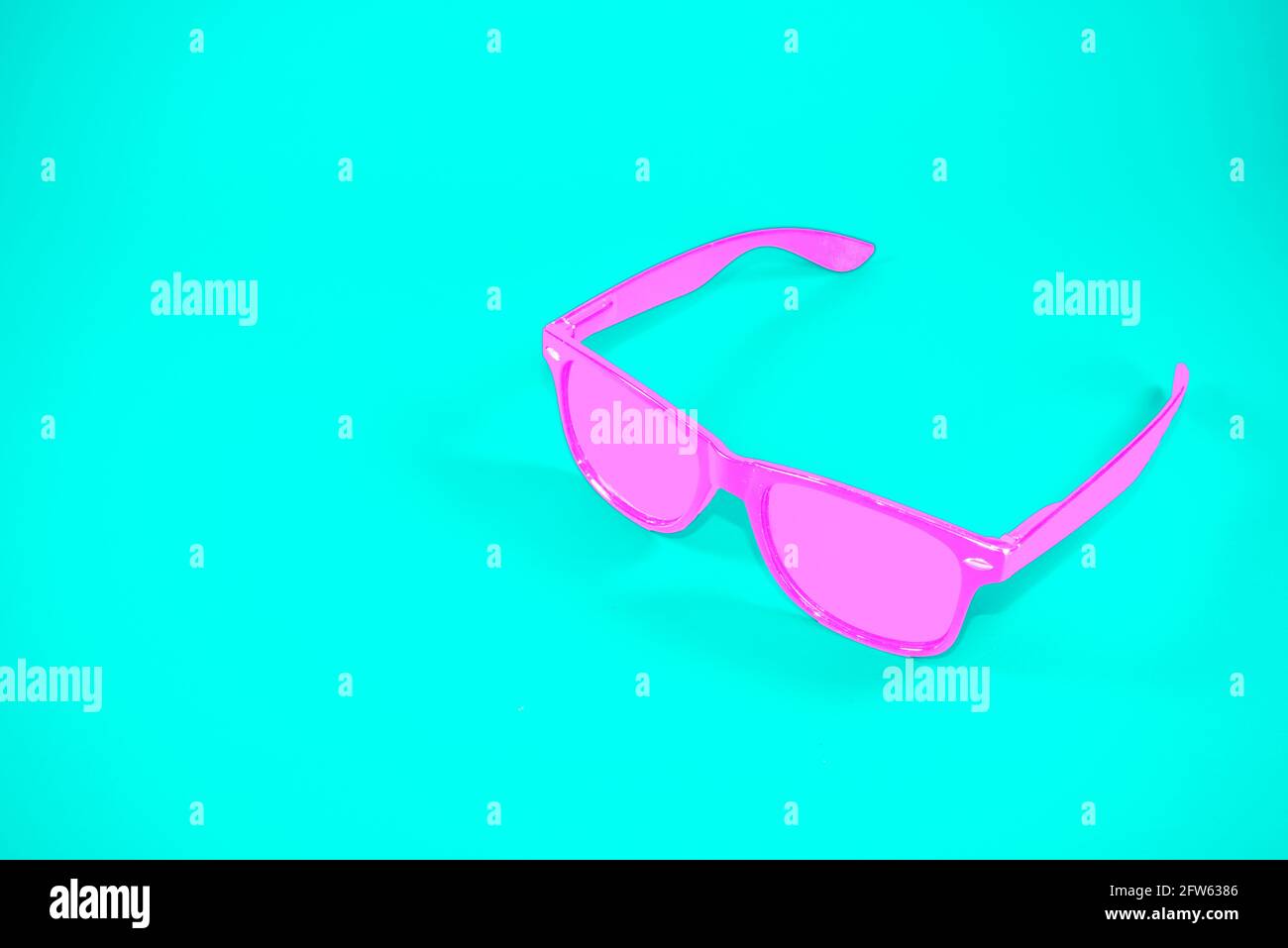 Occhiali retrò rosa su sfondo blu alla moda. Concetto estivo astratto minimo. Con spazio per la copia. Foto Stock