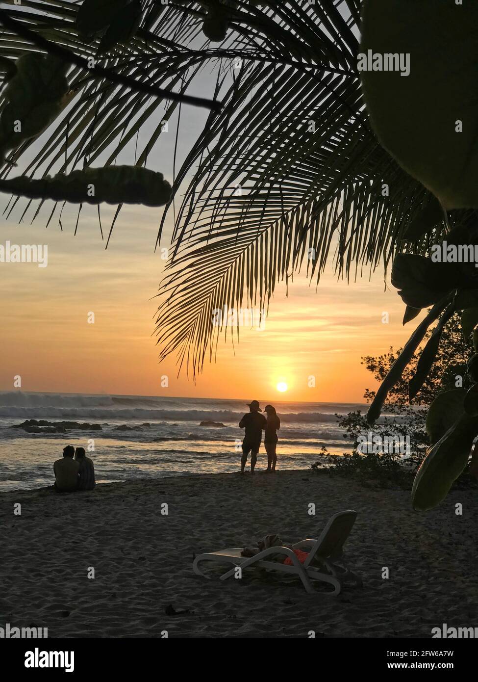 Persone che godono il tramonto da una spiaggia in Costa Rica Foto Stock