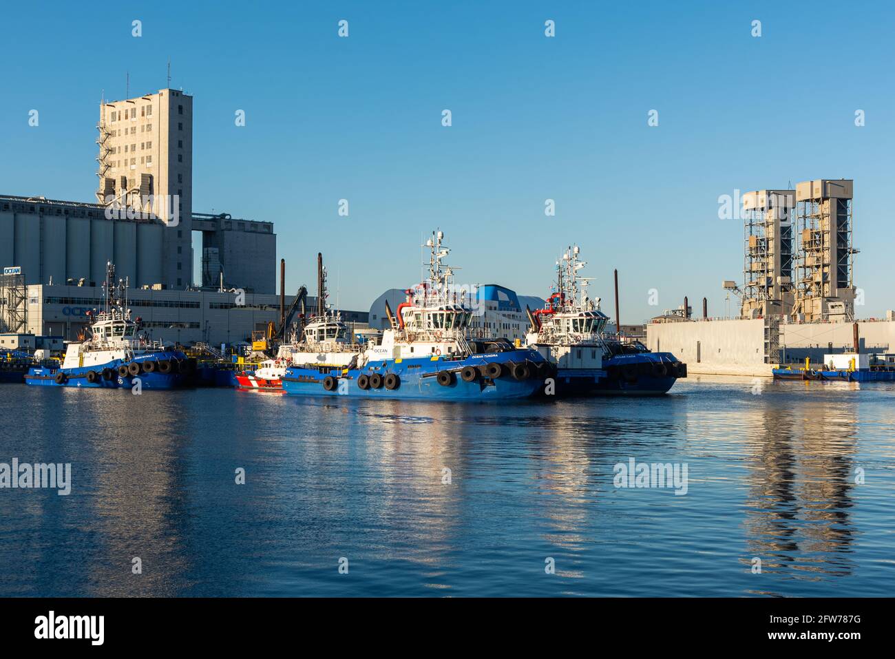 Tugs nel porto della città di Quebec con elevatore di grano industriale in background Foto Stock
