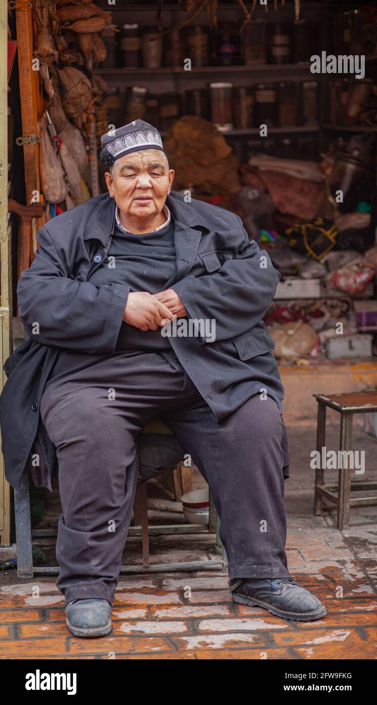 Grande uomo seduto fuori dalla sua tenda Kashgar, Xinkiang, Repubblica popolare Cinese, 2019 Foto Stock