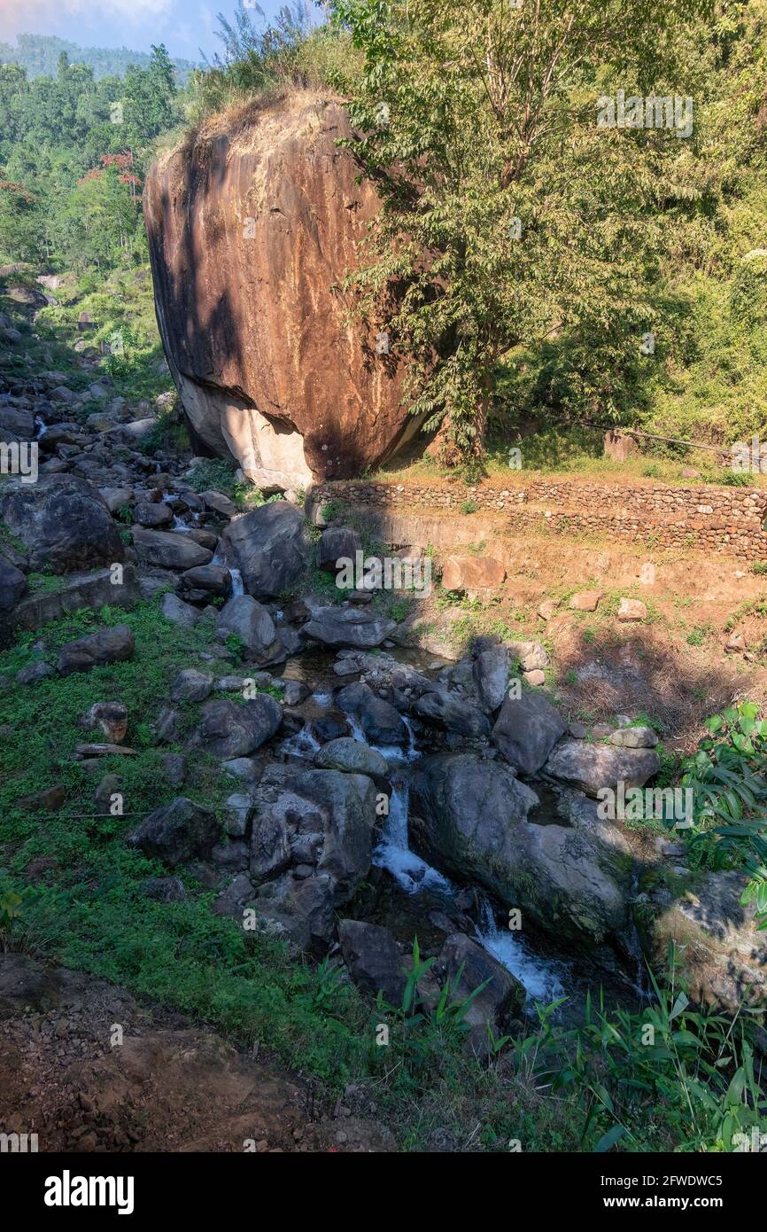 Immagine verticale di pietra di mela - una grande roccia a forma di mela accanto ad un fiume, bella immagine di riserva naturale di Jhalong, Dooars, Bengala del Nord - Bengala Occidentale , Foto Stock
