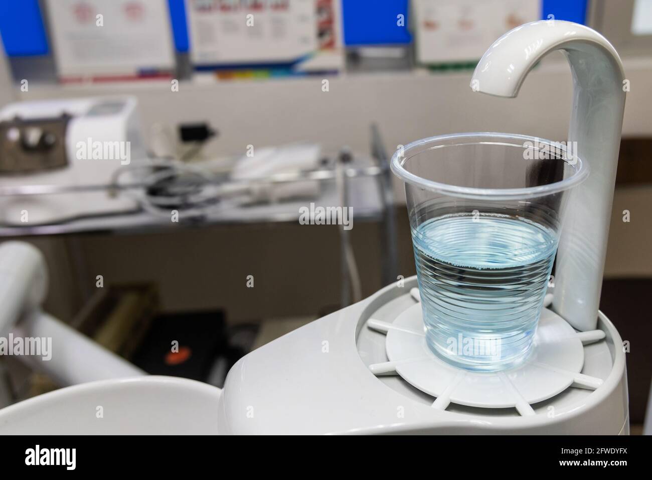 Risciacquo della bocca contenente acqua e antisettico in chirurgia clinica dentale camera Foto Stock