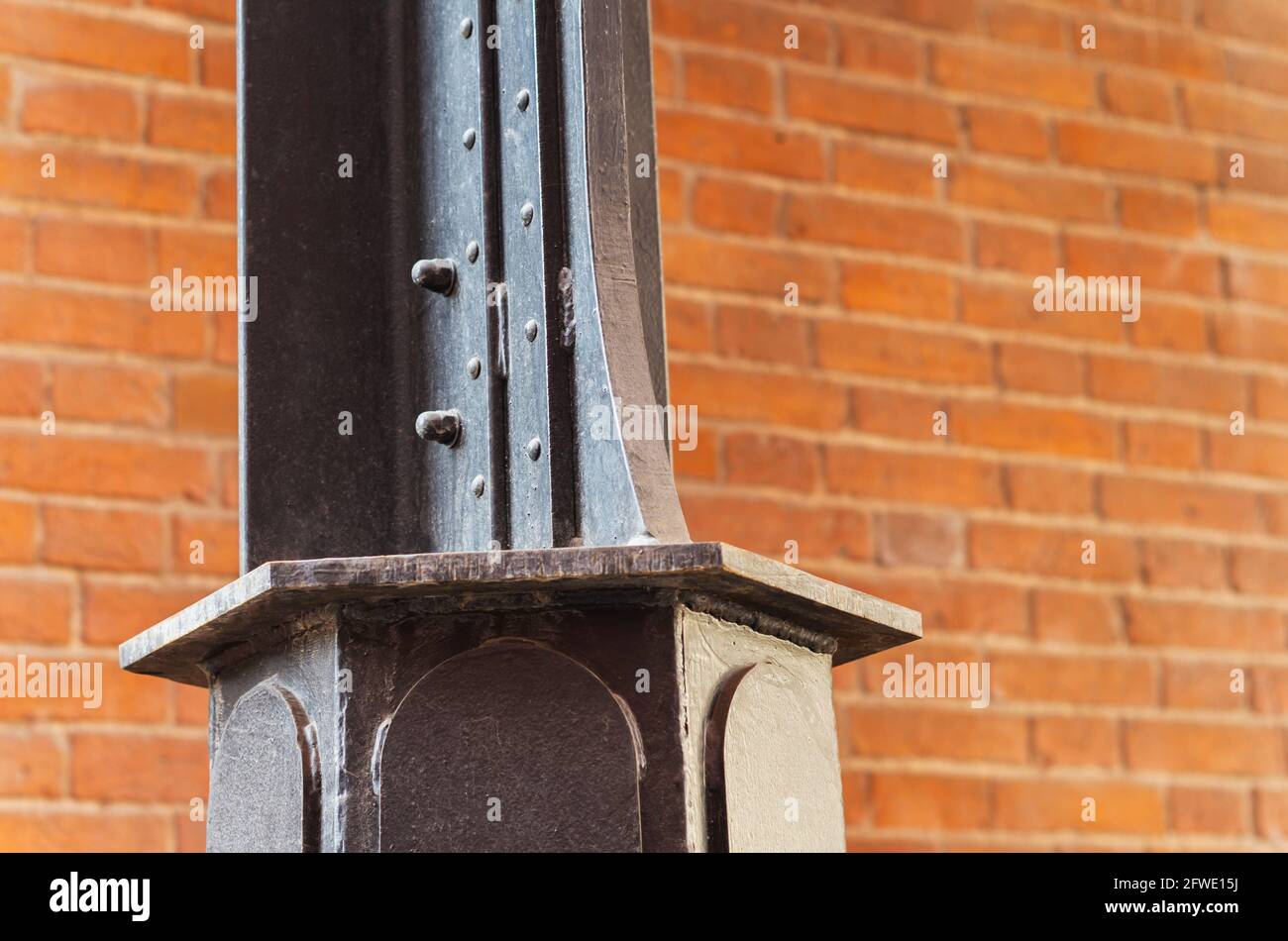 Trave in metallo e parete in mattoni. Punto nodale della struttura dell'edificio. Contesto astratto sul tema dell'architettura moderna. Foto Stock