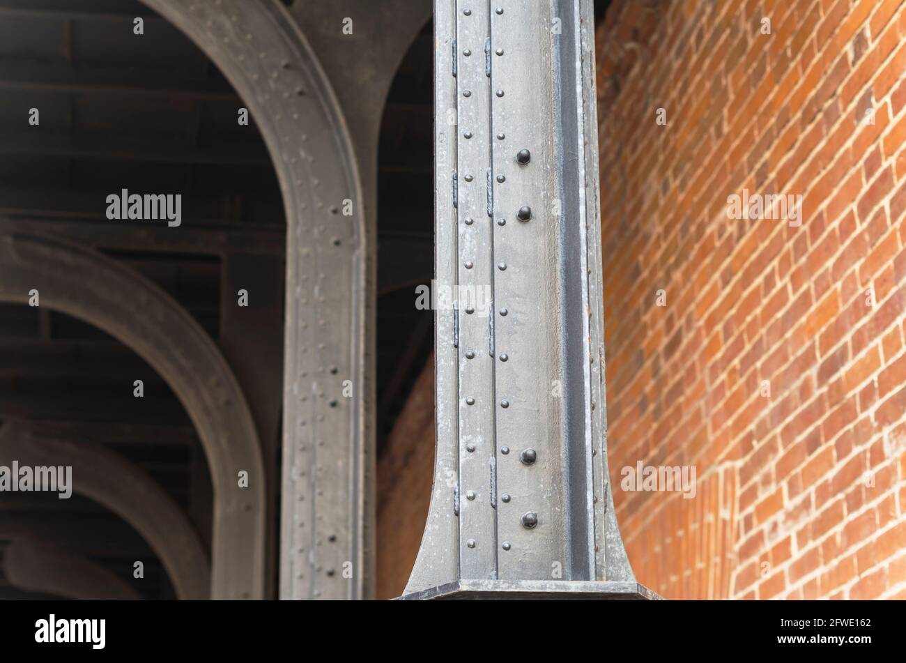 Trave in metallo e parete in mattoni. Punto nodale della struttura dell'edificio. Contesto astratto sul tema dell'architettura moderna. Foto Stock