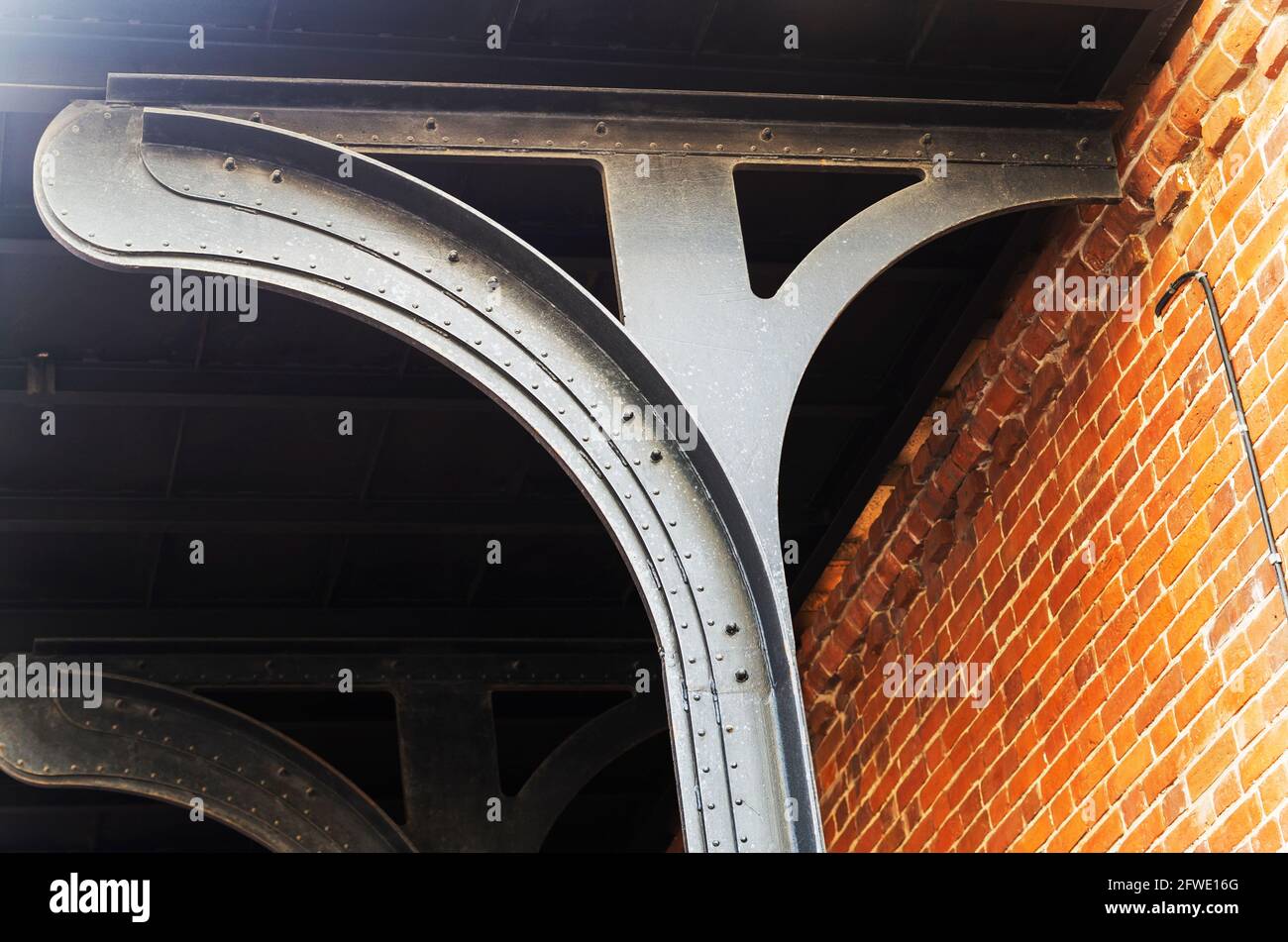 Trave in metallo e parete in mattoni. Punto nodale della struttura dell'edificio. Contesto astratto sul tema dell'architettura moderna. Foto Stock