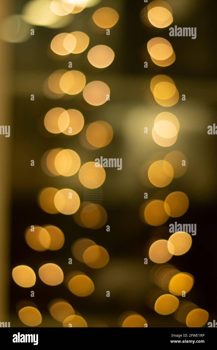 Luci sfocate scintillanti sfondo, luci dorate sfocate su sfondo scuro. Foto Stock