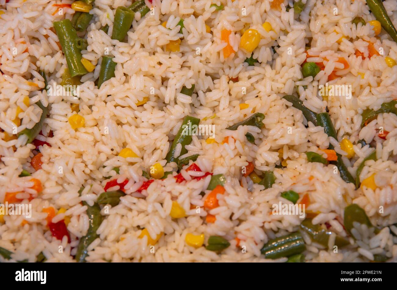 Riso bianco a grani lunghi cotto con verdure ed erbe, sfondo. Foto Stock
