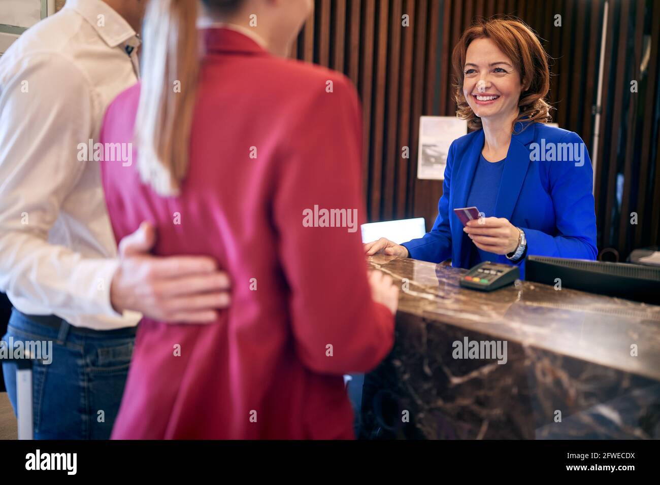 giovane adulto caucasico coppia di affari che effettua il check out alla reception in hotel Foto Stock