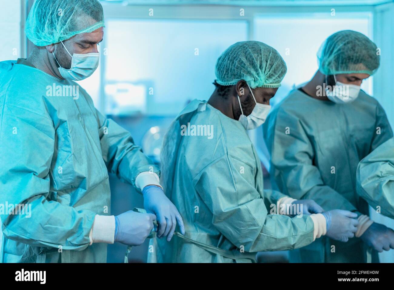 Medici che si preparano per l'intervento chirurgico in ospedale durante l'epidemia di corona virus - operatori medici che si preparano per la lotta contro il coronavirus Foto Stock