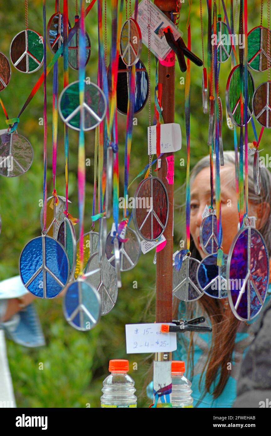 Una donna che sta navigando in un chiosco con colorate collane di simboli anti-nucleari CND in mostra al Festival della Pace di Spearhead, San Francisco, USA. Settembre 2007 Foto Stock