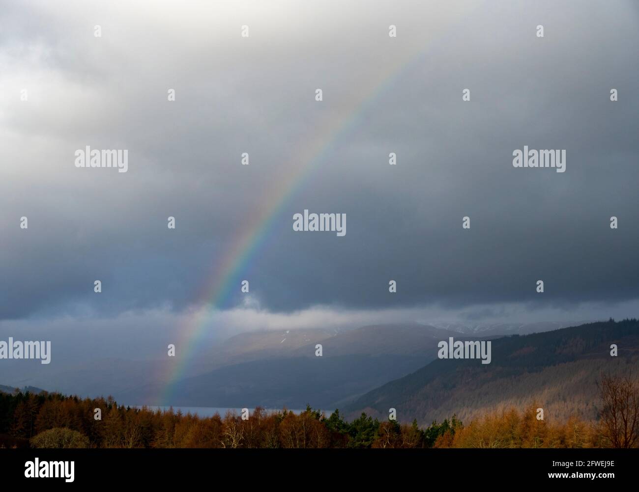 Arcobaleno sul Loch Tay con la Drummond Hill Forest e la catena montuosa Ben Lawers sullo sfondo Foto Stock